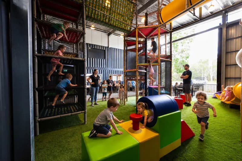Kids at the table beside the Play Pen nets